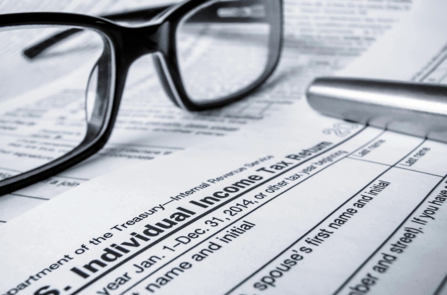 A pair of glasses sitting on top of an individual income tax return.